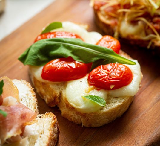 Bruschetta de Muçarela de Búfala, Tomate Confit e Rúcula